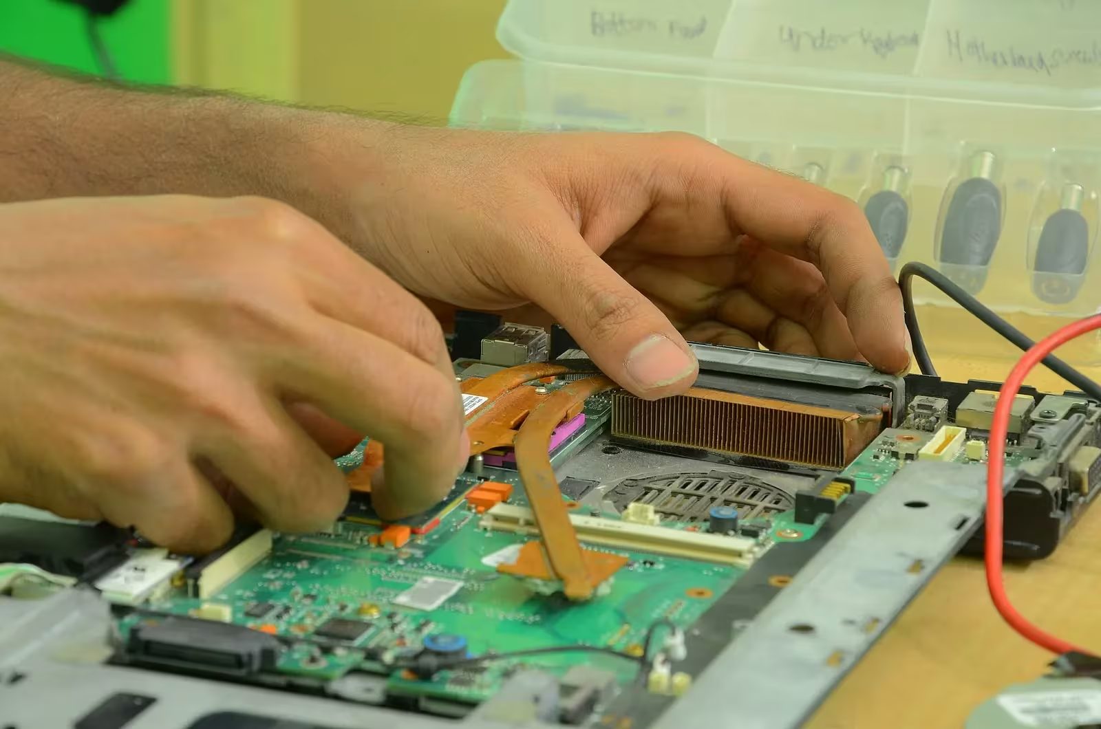 Técnico realizando reparo em computador sobre bancada de serviço