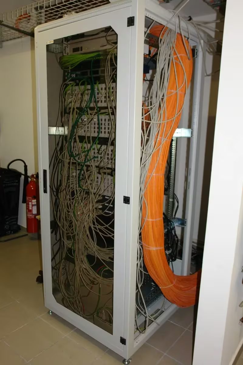 Rack de rede com switches e cabeamento estruturado organizado